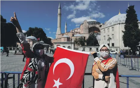  ?? Reuters ?? The Turkish flag is carried to the Hagia Sophia after a court ruling brought its rededicati­on as a mosque closer