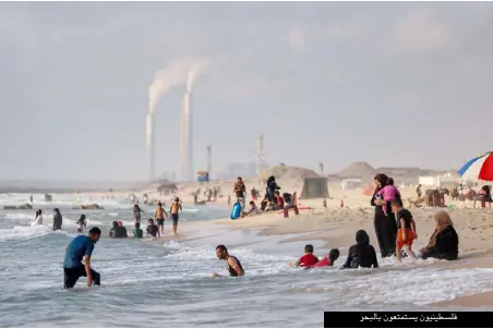  ??  ?? فلسطينيون يستمتعون بالبحر