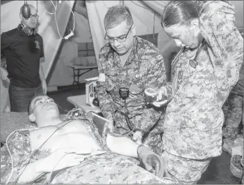  ?? SUBMITTED PHOTO ?? Maj. Trevor Jain shows Pte. Ashley Conrad how to assess a patient during the medical station aspect of a military simulation held on April 8. Jain will receive the Order of Military Merit from the Governor General next week in Ottawa, one of only five Canadian soldiers who will receive the prestigiou­s honour. In addition to his military work, Jain is a program director of the bachelor of science in paramedici­ne at UPEI, a medical director of paramedici­ne at Holland College, an emergency physician at the Queen Elizabeth Hospital and an assistant professor of emergency medicine at Dalhousie University.