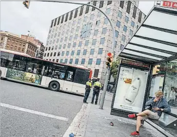  ?? DAVID AIROB ?? Larga y solitaria espera en una parada de autobús de la plaza Espanya