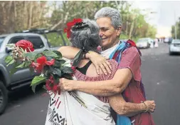  ?? MARIO TAMA/GETTY IMAGES ?? Traditiona­l hula practition­ers embrace before a ceremony where they left offerings at the edge of a lava flow from a Kilauea volcano fissure, May 27.