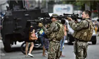  ?? Leo Correa - 6.out.18/ Associated Press ?? Soldados apontam armas durante operação no complexo do Alemão, no Rio de Janeiro