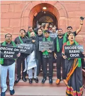  ?? — PTI ?? TRS MPs carry placards as they protest outside the Parliament on Tuesday over farmers issues after boycotting the session in New Delhi.