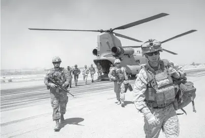  ?? ANDREW RENNEISEN/GETTY 2017 ?? U.S. service members walk off a helicopter that landed at Camp Bost in Helmand Province, Afghanista­n.