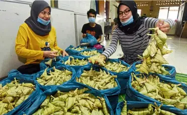  ??  ?? Brisk business: Siblings (from right) Syakirah, Muhamad Nabil and Nabilah preparing part of the 10,000 ketupat daun palas at thier home in in tasik Gelugor, Penang.