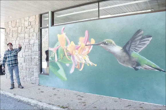  ?? Rachel Dickerson/The Weekly Vista ?? Artist Graham Edwards of Bella Vista describes his process for creating the mural "Flying Jewel" at the Bella Vista Public Library on April 5.