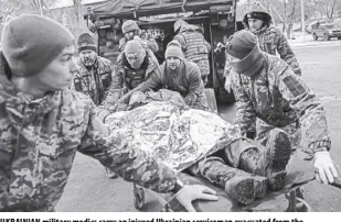  ?? AP/EVGENIY MALOLETKA ?? UKRAINIAN military medics carry an injured Ukrainian serviceman evacuated from the battlefiel­d into a hospital in Donetsk region, Ukraine, on Monday, January 9, 2023. The serviceman did not survive.