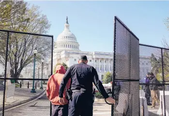  ?? AMR ALFIKY/THE NEW YORK TIMES ?? A Capitol Police officer opens a gate outside the Capitol building Saturday in Washington, near where a car rammed into a security barrier Friday, killing an 18-year veteran of the force. The driver was shot and killed.