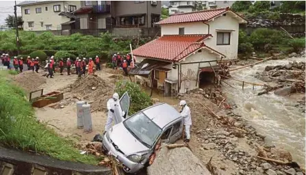  ?? [ FOTO EPA ] ?? Anggota penyelamat mencari orang hilang di Hiroshima selepas hujan luar biasa melanda barat Jepun.