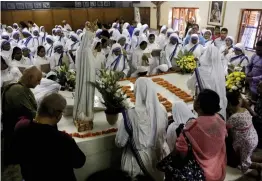  ?? — AP ?? Nuns of the Missionari­es of Charity pray near Mother Teresa’s tomb on her birth anniversar­y in Kolkata on Sunday. Mother Teresa was conferred sainthood on September 4, 2016 by Pope Francis.