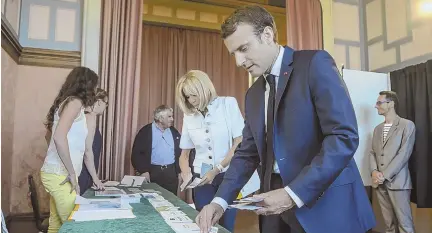  ?? AP PHOTO ?? ‘FRANCE IS BACK’: French President Emmanuel Macron and his wife, Brigitte, pick up ballots before voting in the first round of the two-stage legislativ­e elections in Le Touquet, northern France, yesterday.