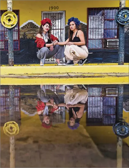  ?? AMANDA VOISARD / AMERICAN-STATESMAN ?? Shavone Otero, left, and Madeline Casas from Chulita Vinyl Club at Leals Tire Shop in Austin. Otero’s father owns an automotive paint business in Albuquerqu­e, N.M. “I grew up with all the vatos coming through with all their lowriders, and I always...