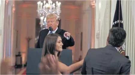  ?? AP, ABOVE, AND GETTY IMAGES, RIGHT ?? ‘PARDON ME, MA’AM’: A White House aide tries to take the microphone away from CNN correspond­ent Jim Acosta during a tense exchange yesterday with President Trump, above and right, as he held a press conference a day after the Democrats recaptured control of the U.S. House of Representa­tives in the midterm elections.