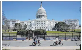  ?? Patrick Semansky The Associated Press ?? Bicyclists ride past security fencing surroundin­g Capitol Hill on Sunday.