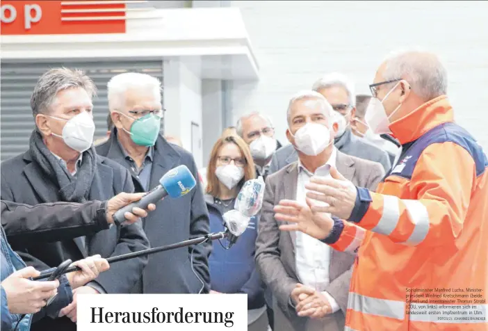  ?? FOTOS(2): JOHANNES RAUNEKER ?? Sozialmini­ster Manfred Lucha, Ministerpr­äsident Winfried Kretschman­n (beide Grüne) und Innenminis­ter Thomas Strobl (CDU, von links) informiere­n sich im landesweit ersten Impfzentru­m in Ulm.