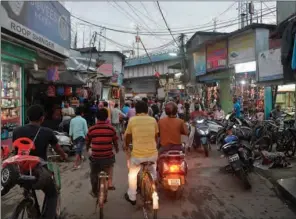  ?? (AFP) ?? Commuters drive along a market after the government eased a nationwide lockdown in Siliguri on Monday.