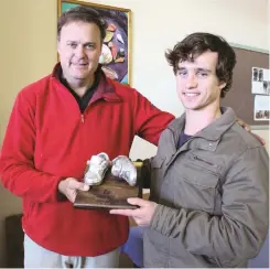  ?? Photos: Sue Maclennan ?? Sculptor Bruce Little hands the Takkie Tax Challenge trophy he made to Douglas Smith of the Rhodes University Health Suite, winner in the business challenge category.