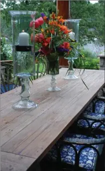  ?? PHOTOS BY MARY CAROL GARRITY, TNS ?? The wooden dining table on the patio stays out year-round. It gets a few coats of polyuretha­ne at thhe beginning of each patio season.