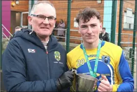  ?? ?? Colaiste na hÍnse captain Sam Moore accepts the Dave Colgan Cup from Donal O’Boyle of the FAI schools’ Leinster branch.
