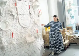  ?? AP PHOTOS ?? Joana Vasconcelo­s points at a full size work model of a section of her 12 metres high and 15 metres wide ceramic wedding cake, at her studio in Lisbon.