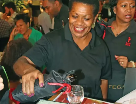  ?? Photo: Josefa Babitu ?? Top Dog Catering staff, Elenoa Tabua, pours a glass of wine.