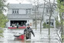  ?? RYAN REMIORZ/THE CANADIAN PRESS ?? Residents use canoes to access their home Monday in Deux-Montagnes, Que.