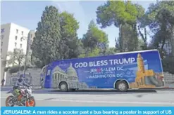  ??  ?? JERUSALEM: A man rides a scooter past a bus bearing a poster in support of US President ahead of the visit of the US vice president to Israel yesterday. US Vice President Mike Pence is on a Middle East tour overshadow­ed by anger in the Arab world over...