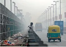  ?? PHOTO: REUTERS ?? A man chews sugarcane on a bridge during a smoggy morning in New Delhi, India.