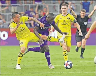  ?? [JOHN RAOUX/THE ASSOCIATED PRESS] ?? David Guzman of the Crew tries to get his foot on the ball against Orlando City’s Benji Michel as the Crew’s Wil Trapp follows.