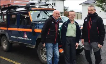  ??  ?? Céilí organiser, John Nolan (centre) pictured with Kerry Mountain Rescue Team members, Mick Long (left) and Mike Ward at Knockgoshe­l Community Centre. Photograph Courtesy of KMRT