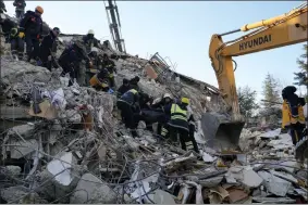  ?? AP PHOTO/KAMRAN JEBREILI ?? Firefighte­rs carry a dead body from a destroyed building, in Gaziantep, southeaste­rn Turkey, Wednesday, Feb. 8, 2023. Thinly stretched rescue teams worked through the night into Wednesday, pulling more bodies from the rubble of thousands of buildings downed in Turkey and Syria by a catastroph­ic earthquake.