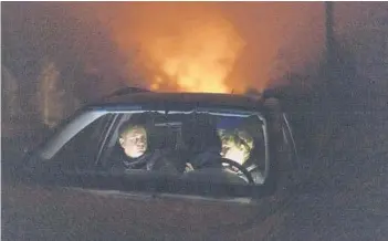  ?? ?? Piotr Bystrianin and Dorota Nowok of a refugee aid group wait in a car earlier this month for a signal from a family of migrants they have been helping in Poland near the border with Belarus.