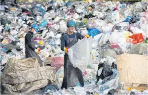  ??  ?? Workers sort plastic waste at the Yongin Recycling Center in Yongin, South Korea. The coronaviru­s is underminin­g global efforts to ease plastic pollution, with lockdown measures curbing recycling activity.