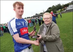  ??  ?? Minor Man of the Match award sponsor Mrs Price presents Eire Óg’s Conor Fulham with his award after the final in Pearse’s Park.