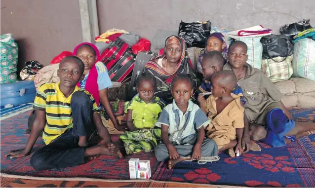  ?? KRISTA LARSON/ THE ASSOCIATED PRESS ?? Yaman Ahmat, centre, sits with her children at Bangui Airport. Only hours earlier, her husband had put her and their eight children on a flight to the capital in a desperate effort to save their lives. The husband was killed as he was returning from...