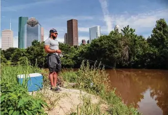  ?? Marie D. De Jesus/Staff file photo ?? Sean Burns, 20, fishes last June at Buffalo Bayou. State health officials advise against eating catches from the area’s estuaries because of Ship Channel pollution