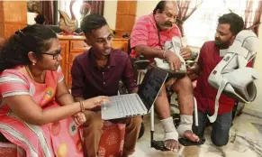  ??  ?? Needful things: (From left) Thilageswa­ry and Shakkthive­l looking at the laptop while Kandiah and Seevaratna­m look at the orthotic walker.