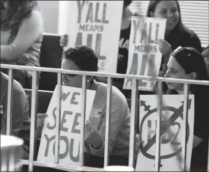  ?? CHRIS SEWARD/ RALEIGH NEWS & OBSERVER ?? Opponents of HB2 hold signs inside the North Carolina Senate chambers gallery as the North Carolina General Assembly convenes for a special session on Wednesday at the Legislativ­e Building in Raleigh, N.C.