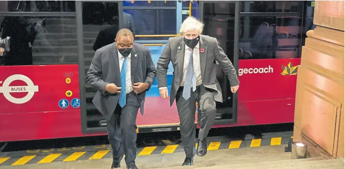  ?? Ap ?? El primer ministro británico, Boris Johnson, y el presidente de Kenia, Uhuru Kenyatta, llegan a la recepción de ayer en un bus eléctrico