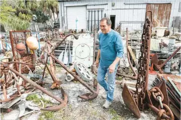  ?? TAMPA BAY TIMES PHOTOS ?? Larry Schiller walks through a maze of ship anchors at Schiller’s Architectu­ral & Design Salvage in Tampa.