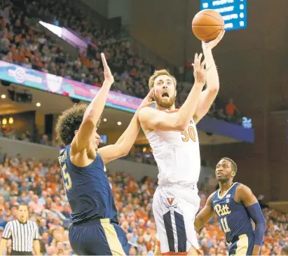  ?? RYAN M. KELLY/GETTY IMAGES ?? Virginia's Jay Huff draws a foul from Pittsburgh's Kene Chukwuka during Saturday's second half, which featured plenty of U.Va. reserves.