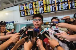  ??  ?? This file photo shows Hong Kong democracy campaigner Joshua Wong (center) speaking during a press conference upon his arrival at the internatio­nal airport in Hong Kong, after being deported from junta-run Thailand. — AFP