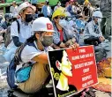  ??  ?? A protester holds a sign. (AFP)