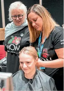  ??  ?? Chief hair designer Cherie McIntyre checks in on WelTec hairdressi­ng student CasperRose Marama backstage at WOW.