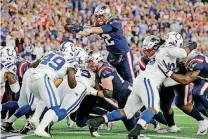  ?? [AP PHOTO] ?? New England Patriots quarterbac­k Tom Brady leaps over the line of scrimmage for a touchdown against the Indianapol­is Colts during the first half of Thursday night’s NFL game in Foxborough, Mass. For game coverage, go to oklahoman.com/sportspage.