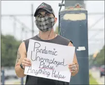  ?? MAX BECHERER — THE NEW ORLEANS ADVOCATE VIA AP ?? Sean Harris pleads for help from passing motorists last week in New Orleans. Harris had just completed training to be a history tour guide in the French Quarter when the coronaviru­s pandemic hit. He has not been able to find a job since.