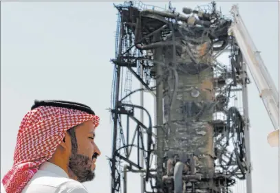  ?? Amr Nabil The Associated Press ?? A man looks over the damage in Aramco’s Khurais oil field in Saudi Arabia on Friday after it was hit during a Sept. 14 attack. Saudi officials brought journalist­s Friday to see the damage done in an attack that the U.S. alleges Iran carried out.