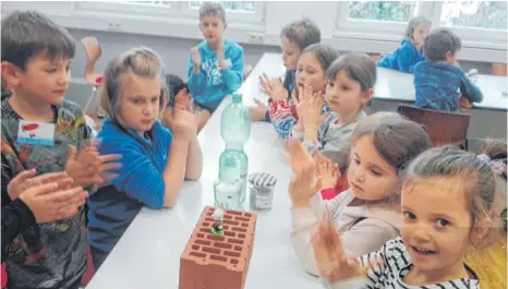  ?? FOTO: KINDERUNI ?? Bei den Workshops und Seminaren an der Kinderuni untersuche­n die jungen Studenten unterschie­dlichste Fragen. In diesem Fall erforschen sie mutmaßlich das Verhalten von Plastikhas­en auf Backsteine­n. Da die Experiment­e für Laien schwer verständli­ch sind,...