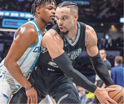  ?? AP ?? Charlotte Hornets guard Dennis Smith Jr. leans on Memphis Grizzlies forward Dillon Brooks during the first half of a Jan. 4 game in Charlotte, N.C.