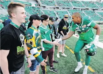  ?? THE CANADIAN PRESS ?? Roughrider­s fullback Spencer Moore shakes hands with Isaac Leicht, who lost his brother Jacob in the crash, as the CFL team hosts Humboldt families at Mosaic Stadium.